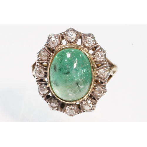8 - Victorian emerald and diamond ring. The ring being set with a large oval green emerald cabochon, sur... 
