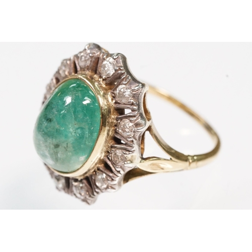 8 - Victorian emerald and diamond ring. The ring being set with a large oval green emerald cabochon, sur... 
