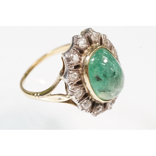 8 - Victorian emerald and diamond ring. The ring being set with a large oval green emerald cabochon, sur... 