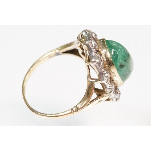 8 - Victorian emerald and diamond ring. The ring being set with a large oval green emerald cabochon, sur... 
