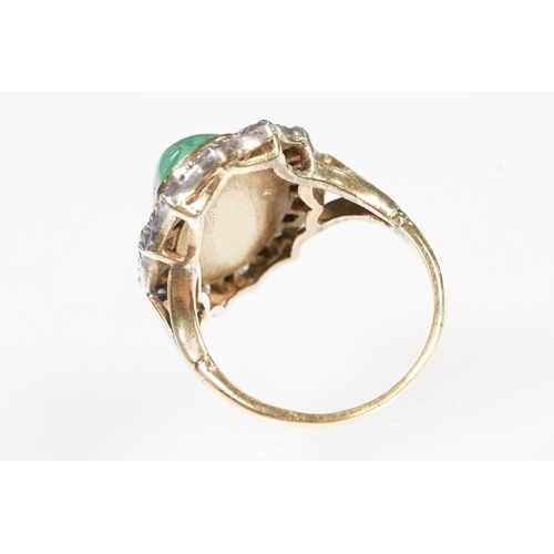 8 - Victorian emerald and diamond ring. The ring being set with a large oval green emerald cabochon, sur... 