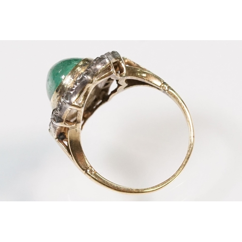 8 - Victorian emerald and diamond ring. The ring being set with a large oval green emerald cabochon, sur... 