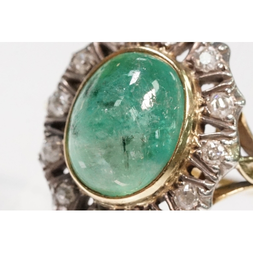 8 - Victorian emerald and diamond ring. The ring being set with a large oval green emerald cabochon, sur... 