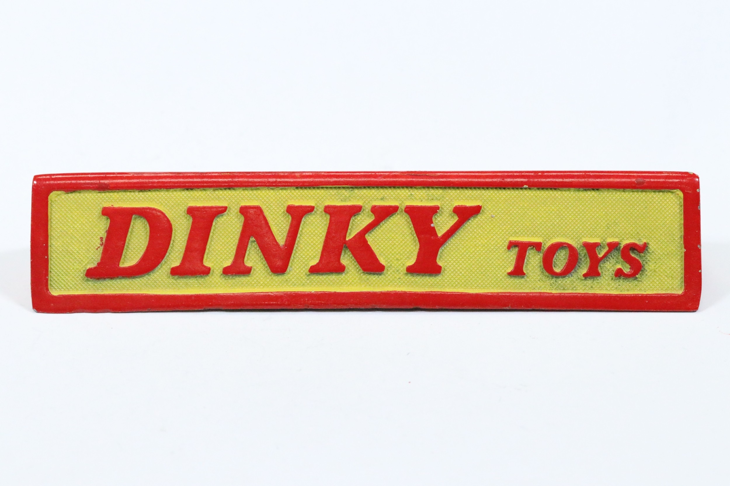 Dinky Toys cast painted metal triangular shop display sign, L 18cm, H ...