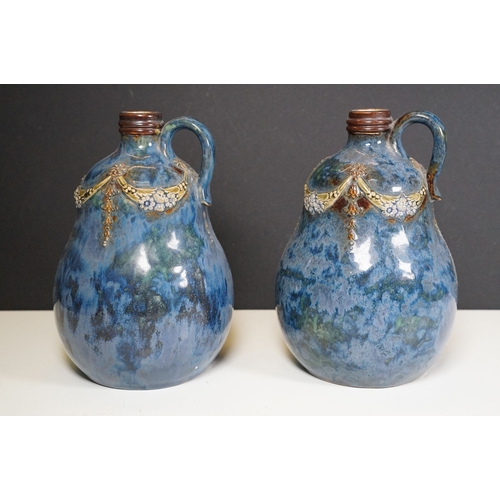 64 - Pair of Royal Doulton stoneware whisky decanters with loop handles, marked to base No. 8895, measure... 