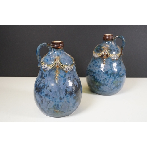 64 - Pair of Royal Doulton stoneware whisky decanters with loop handles, marked to base No. 8895, measure... 