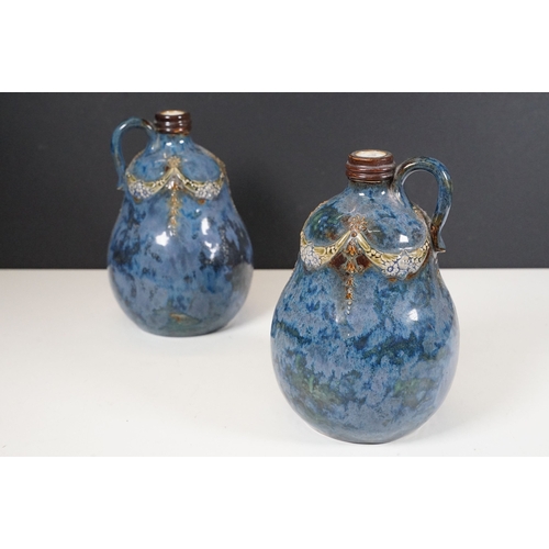 64 - Pair of Royal Doulton stoneware whisky decanters with loop handles, marked to base No. 8895, measure... 
