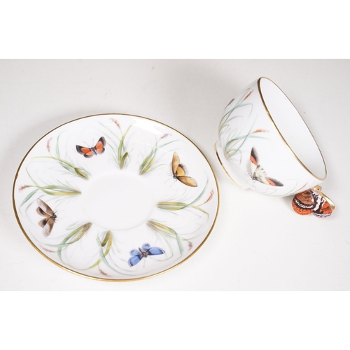68 - Minton hand-painted cup and saucer decorated with butterflies, moths and foliage, the handle modelle... 