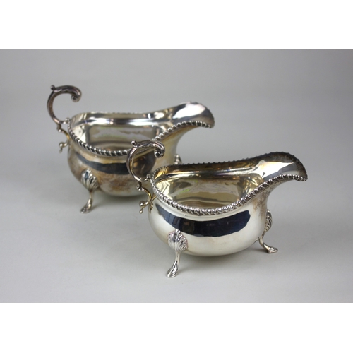 132 - A pair of mid-20th century silver sauceboats each with flying scroll cast handles, gadrooned borders... 