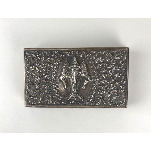 175 - A vintage Asian white metal cigarette box, the hinged lid decorated in relief with three elephants a... 