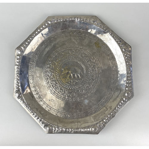 193 - An Asian white metal tray, the dished octagonal form embossed with a central elephant amidst stylise... 