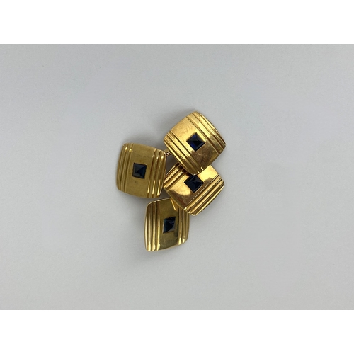 268 - A pair of gold and synthetic sapphire cufflinks, the backs and fronts of curved square form with ree... 