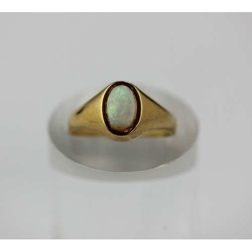 493 - A gold ring mounted with an oval opal detailed '18', ring size L, 3.7g