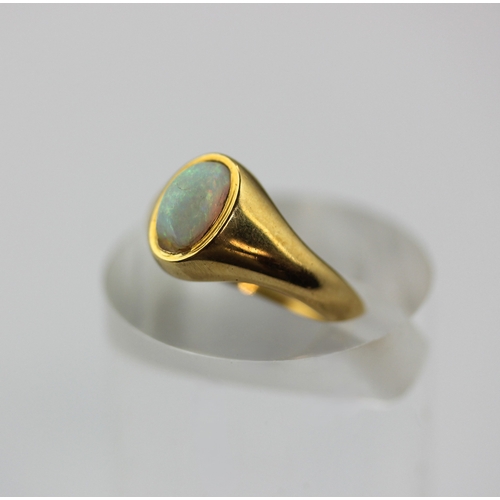 493 - A gold ring mounted with an oval opal detailed '18', ring size L, 3.7g