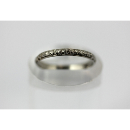 496 - A platinum wedding ring having foliate decoration, detailed 'PLAT', ring size P, 2.3g