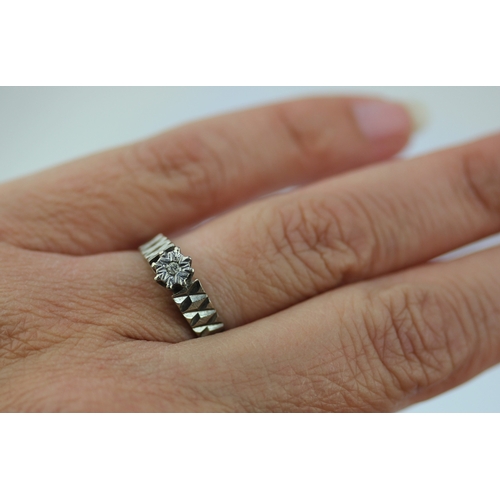 498 - An 18ct white gold and diamond single stone ring mounted with a circular cut diamond between decorat... 