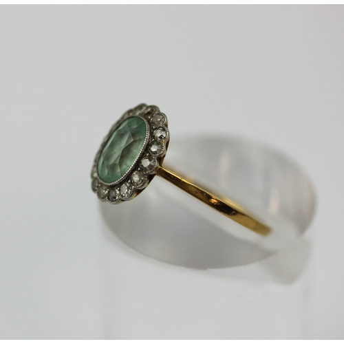 505 - A gold diamond and pale green gemstone oval cluster ring, collet set with the oval cut pale green ge... 