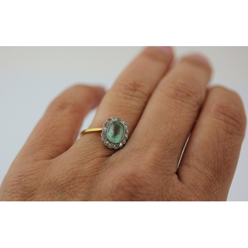 505 - A gold diamond and pale green gemstone oval cluster ring, collet set with the oval cut pale green ge... 