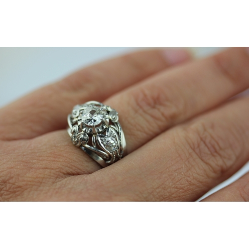 508 - A diamond ring claw set with the principal cushion shaped diamond at the centre between two smaller ... 