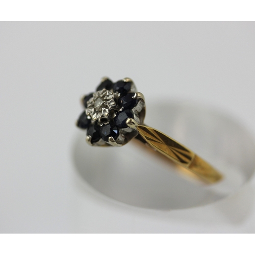 510 - An 18ct gold sapphire and diamond nine stone cluster ring mounted with a circular cut diamond at the... 