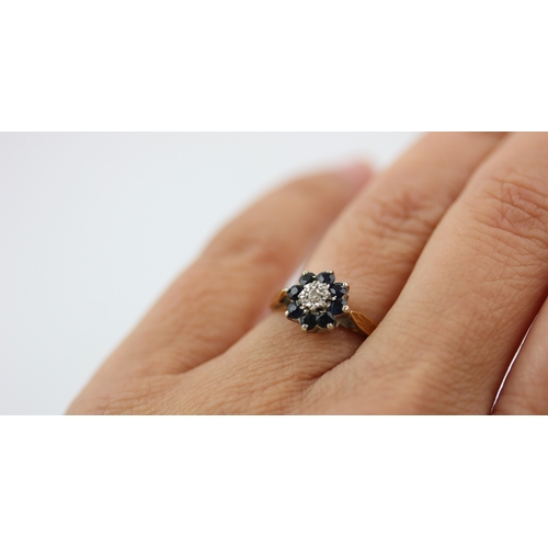 510 - An 18ct gold sapphire and diamond nine stone cluster ring mounted with a circular cut diamond at the... 