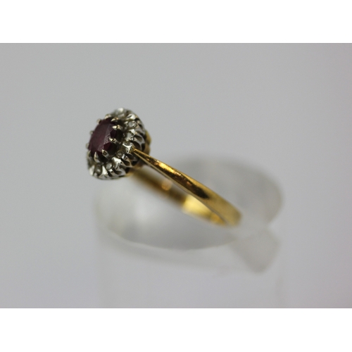 512 - An 18ct gold ruby and diamond oval cluster ring claw set with the oval cut ruby in a surround of cir... 