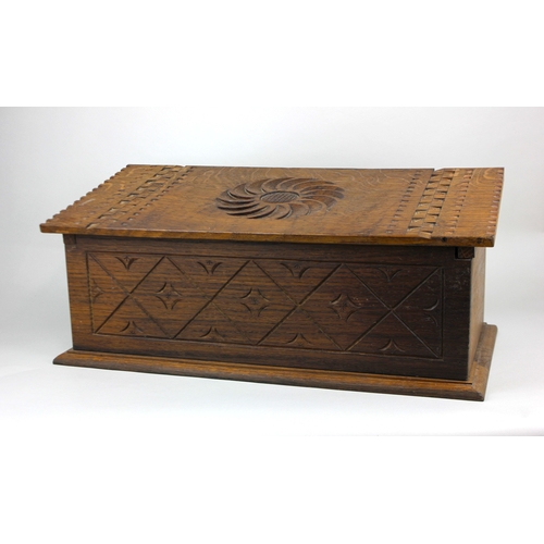 780 - An early 20th century carved oak box sloping top with central medallion, 50cm