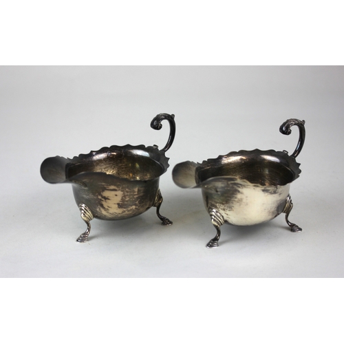 80 - A pair of 20th century silver sauce boats each with flying scroll handles, on three hoofed feet, mak... 