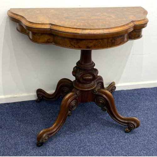 958 - A Victorian walnut card table with shaped demi-lune foldover top on carved baluster stem to four out... 