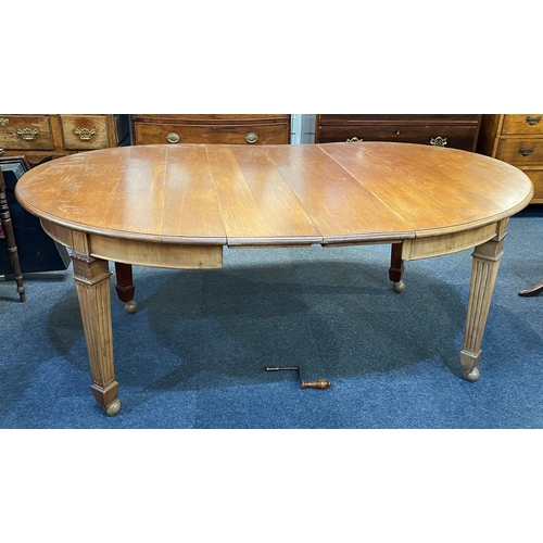 An Edwardian mahogany wind-action extending dining table with two extra ...