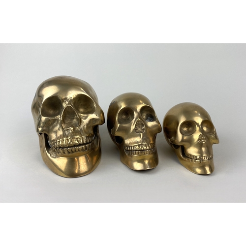 177 - A set of three graduated brass models of skulls, 12cm, 9cm, and 8cm high, (3)... 