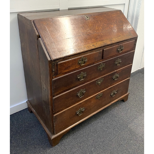 474 - A George III oak bureau with fall enclosing pigeon holes and small drawers, over two short and three... 