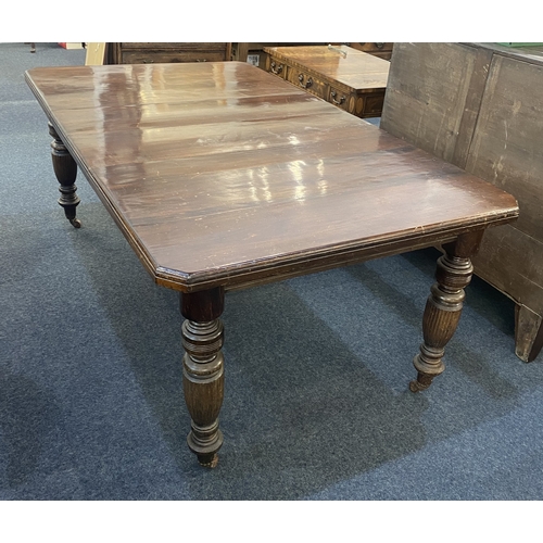 477 - A Victorian mahogany two leaf extending dining table, with rectangular cut cornered top on baluster ... 