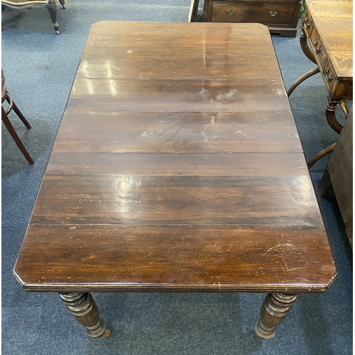 477 - A Victorian mahogany two leaf extending dining table, with rectangular cut cornered top on baluster ... 