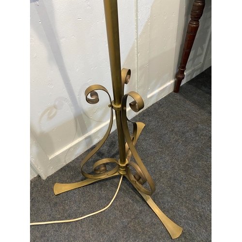 549 - An adjustable brass column standard lamp with three scroll supports and splayed feet... 