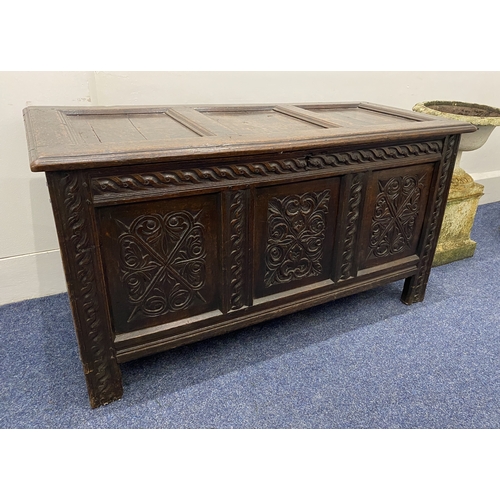 555 - An 18th century oak coffer with carved three panel front and interior with candlebox, 129cm... 