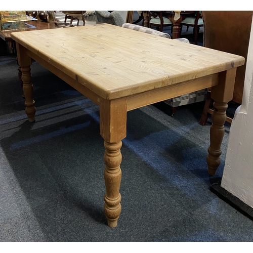 564 - A solid pine kitchen table, 20th century, the rectangular top with rounded corners, raised on turned... 