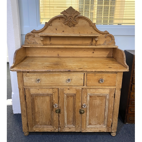 566 - A Victorian stripped pine small sideboard, having an ornate raised back with open shelves, above two... 