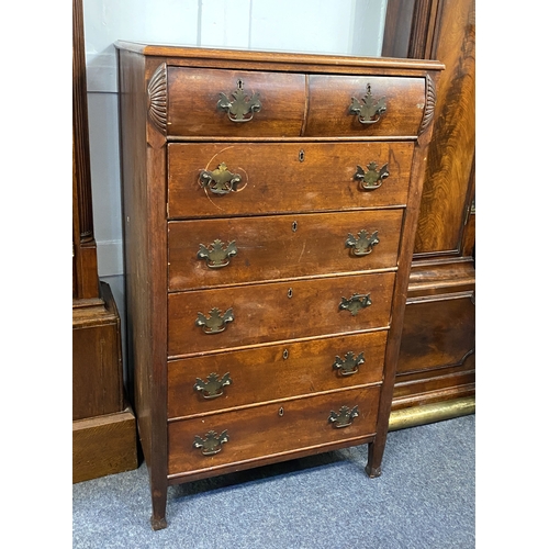 567 - A continental narrow chest of two small cushion drawers, with shell carved surround, over five furth... 