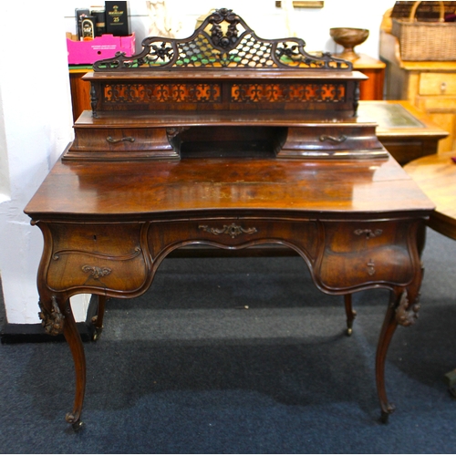 590 - A 19th century rosewood bonheur du jour in the French taste, having an elegant carved and lattice pi... 