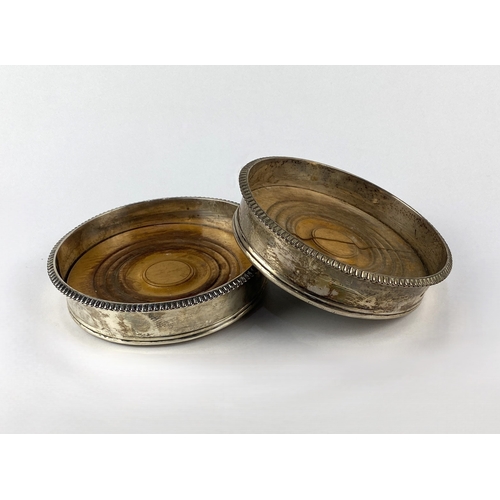 14 - A pair of Scottish Georgian silver wine coaster, with gadrooned cast rims and turned wooden bases, 1... 