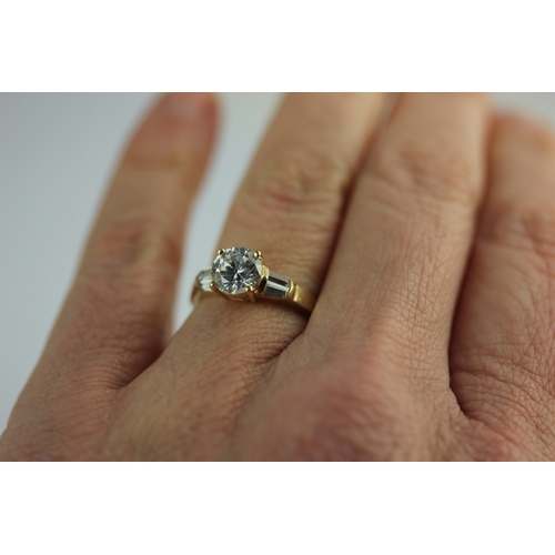 301 - A gold and cubic zirconia ring claw set with the principle circular cut cz at the centre between the... 