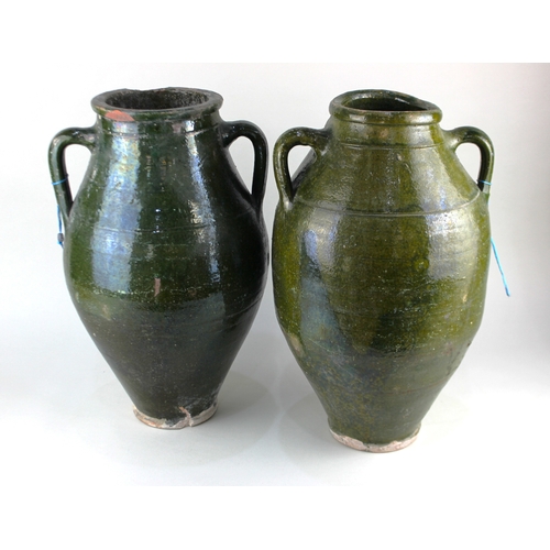 430 - Two similar green glazed earthenware twin handled olive jars, late 19th / early 20th century, 45cm a... 