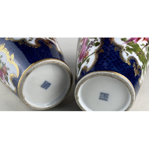 443 - A pair of porcelain vases decorated with exotic birds in a landscape inside gilt frames against a sc... 