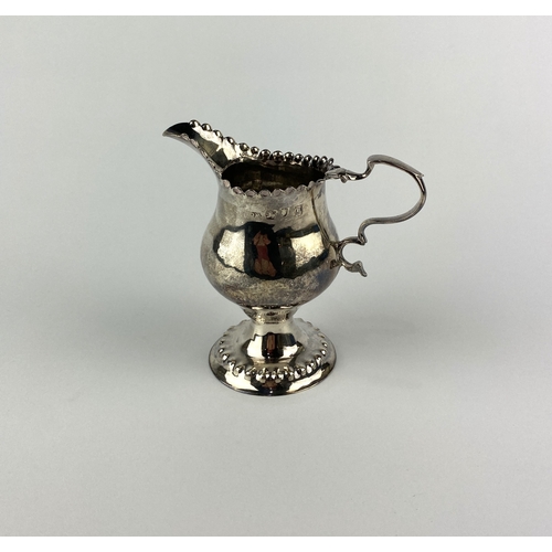 55 - A George II silver cream jug, marks rubbed, London possibly 1758, of baluster form with decorative l... 