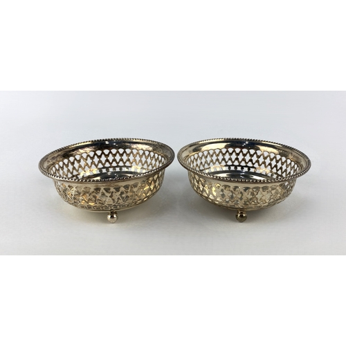 76 - A pair of early 20th century sterling silver dishes, circular form with beaded rims, pierced decorat... 