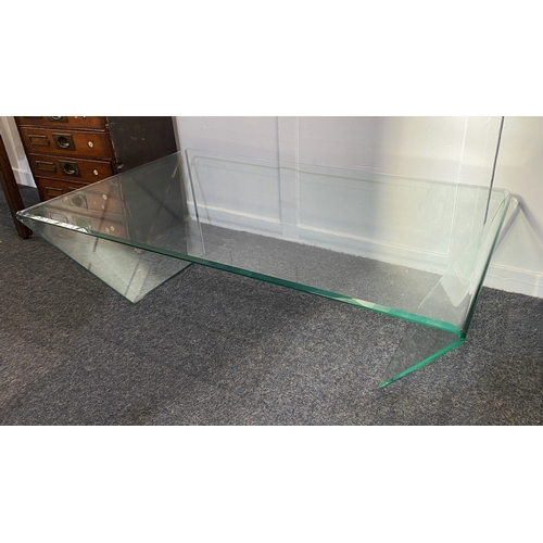 820 - A contemporary rectangular glass coffee table with bevelled edge and sloping supports, 116cm... 