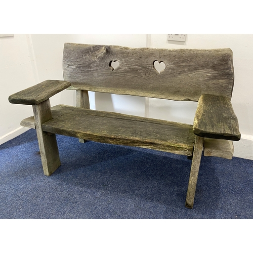 825 - A rustic wooden garden bench with plank seat and back pierced with two hearts, 155cm... 