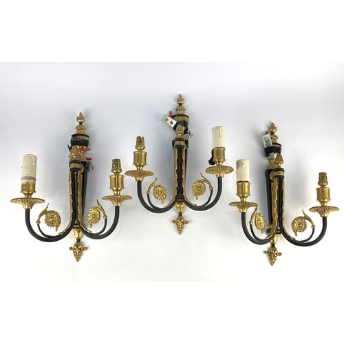 134 - A set of three French Empire style black and gilt brass two-branch wall lights 39cm high... 