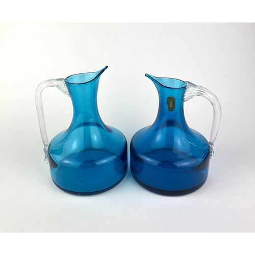 29 - Geoffrey Baxter (1922-1995) for Whitefriars, a matched pair of blue glass jugs with clear handles, o... 